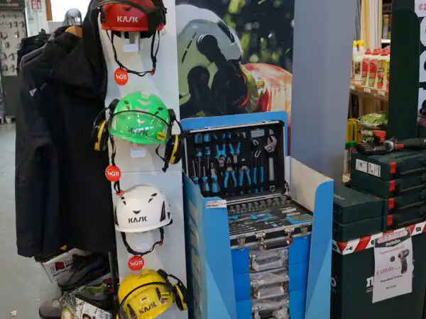 Totem KASK con caschi di protezione esposti su supporto e attrezzatura DPI
