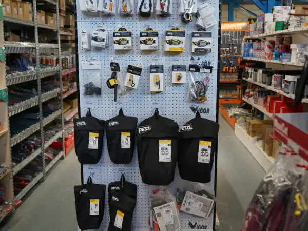 Espositore Petzl con lampade frontali e guanti da lavoro, cartello 'il numero uno della ferramenta'