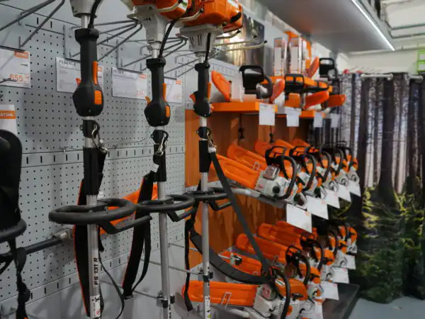 Espositore STIHL con potatori telescopici e tagliasiepi appesi alla parete