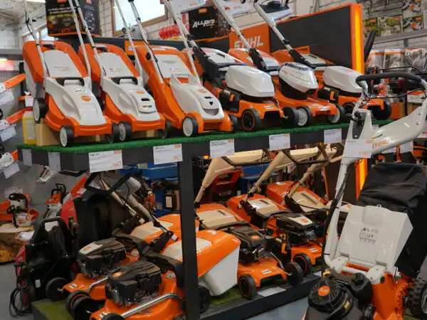 Fila di tosaerba e rasaerba STIHL esposti su scaffale metallico