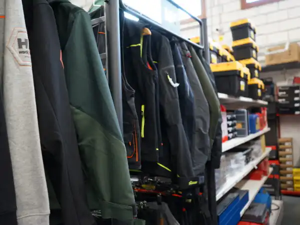 Giacche e softshell da lavoro Helly Hansen appese nel reparto abbigliamento