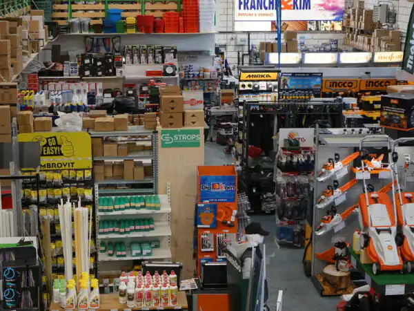 Veduta d'insieme dell'interno del negozio con colorificio Franchi & Kim, macchine STIHL e abbigliamento da lavoro