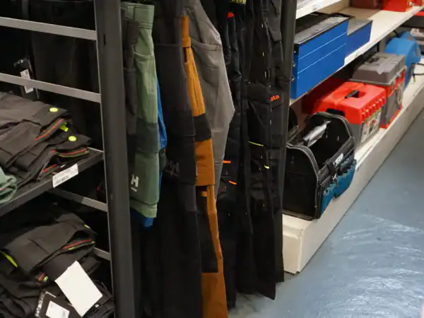 Pantaloni da lavoro appesi negli espositori del reparto abbigliamento