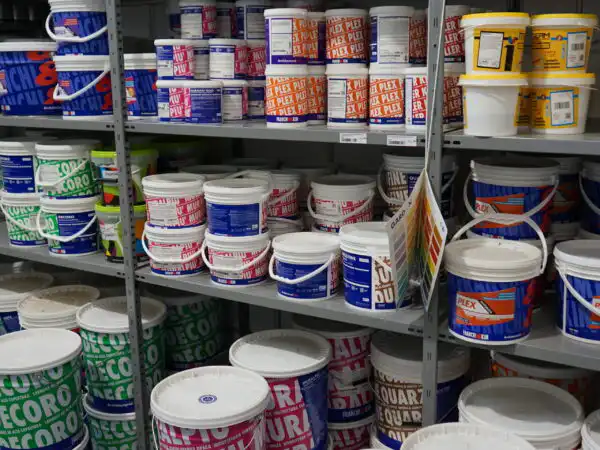 Scaffali del colorificio con barattoli di vernice di varie marche