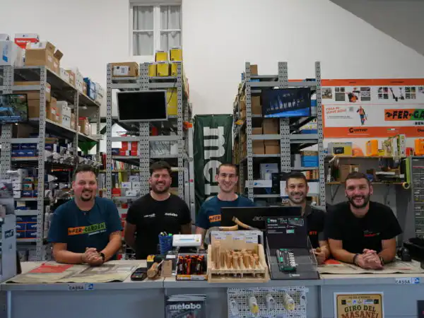 Cinque addetti sorridenti dietro al bancone con insegna FER-GARDEN e cassettiera Metabo