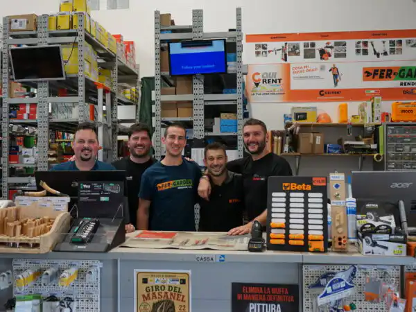 Cinque addetti sorridenti alla cassa con insegna FER-GARDEN RENDENA e cassettiera Beta