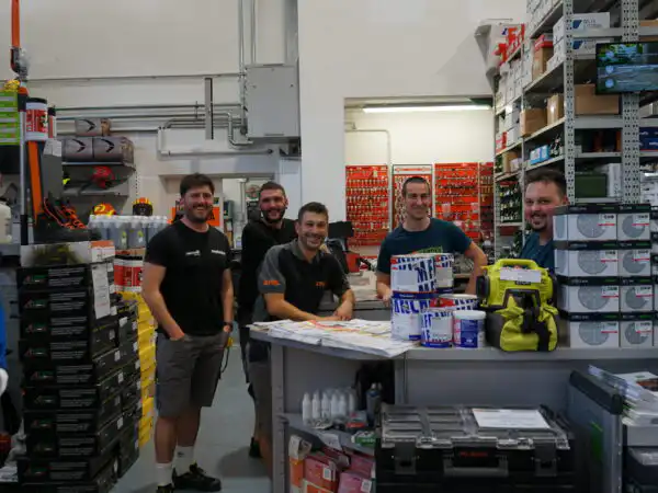 Il team dello staff del negozio posa dietro il bancone tra i reparti