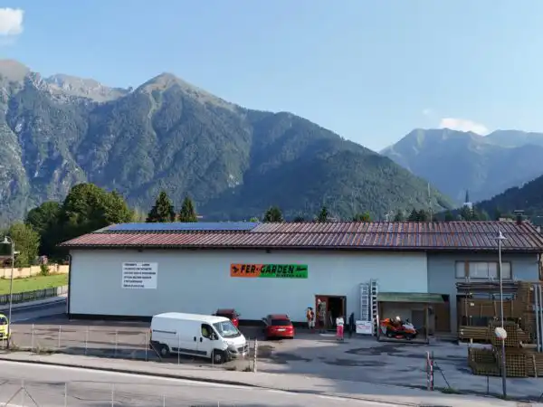 Panoramica aerea del negozio Fer-Garden con tetto, piazzale e montagne della Val Rendena